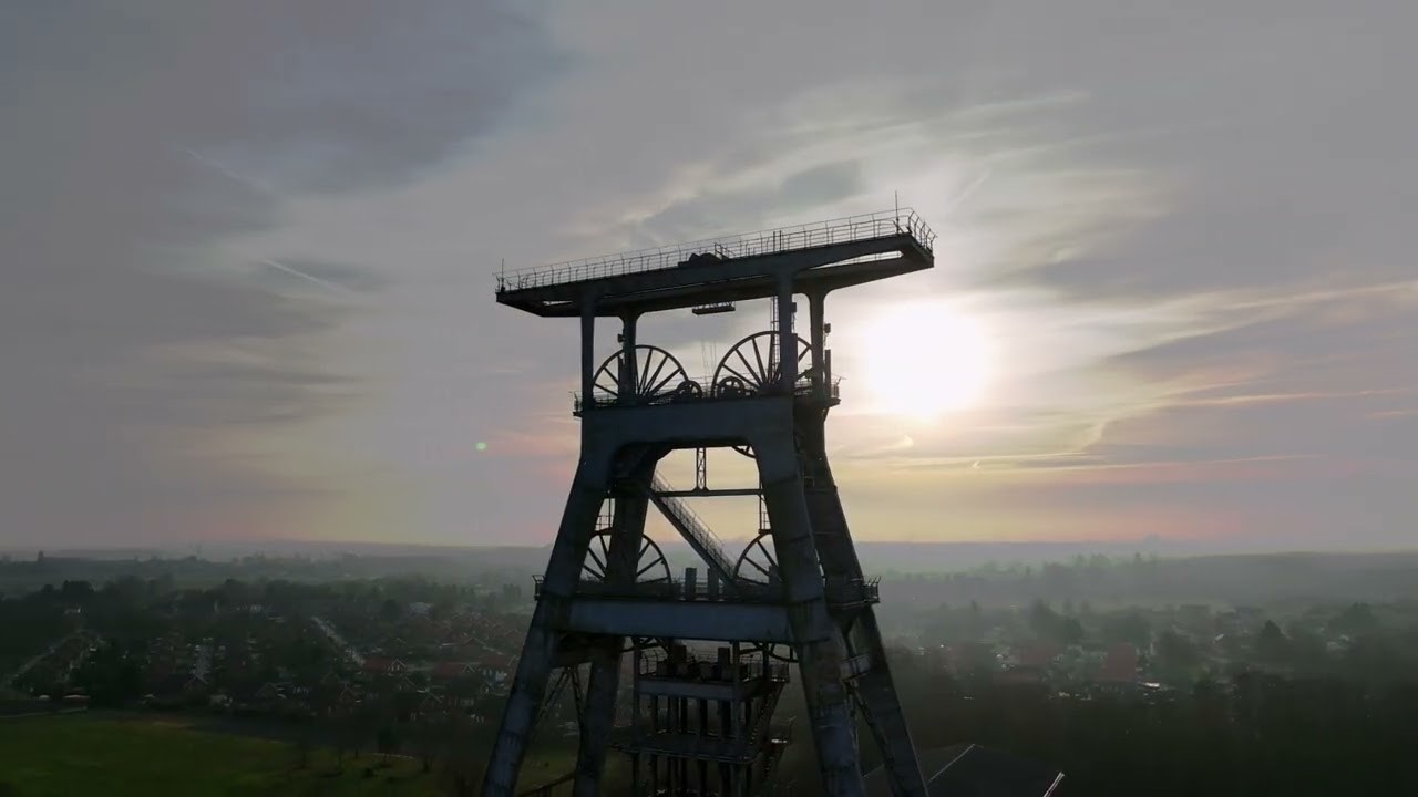 Vue aérienne par drone d'un chevalement minier au coucher du soleil